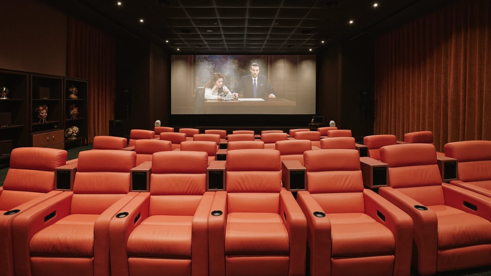 Cine lounge com poltronas reclináveis e telão — imagem ilustrativa