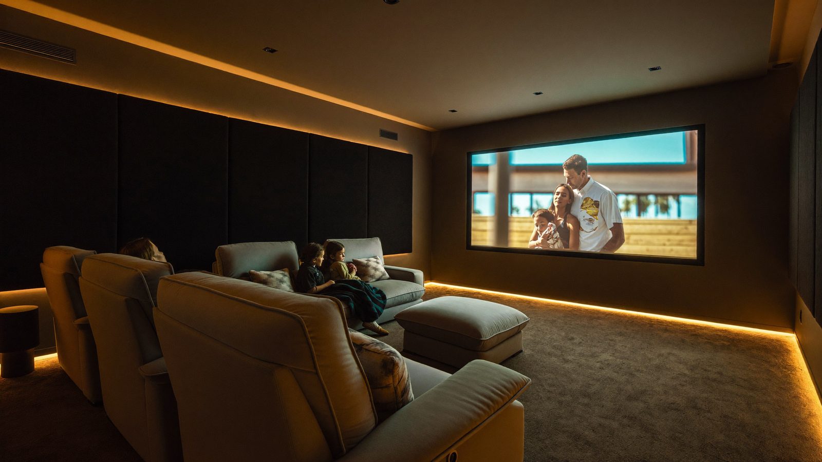 Sala de cinema residencial com família no sofá e iluminação âmbar — imagem ilustrativa