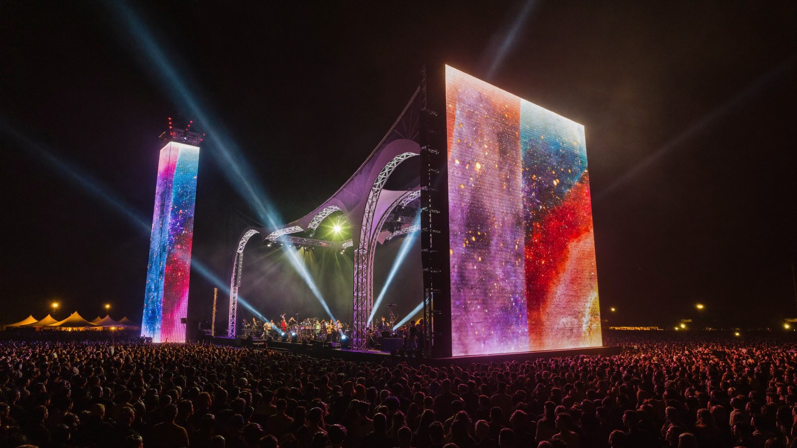 Festival ao ar livre com torres de LED e multidão — imagem ilustrativa